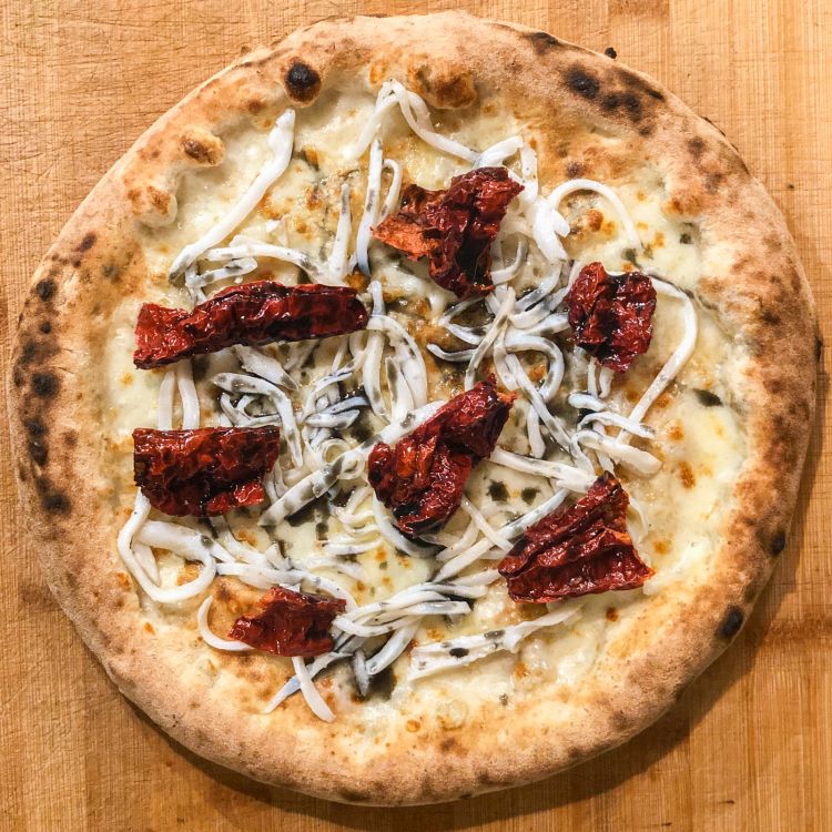La pizza Virgilio Martinez: peperone corno arrostito, tagliatella di seppia cotta a bassa temperatura, fiordilatte e un’emulsione al nero, limone e olio extravergine d'oliva. Disponibile fino al 30 Giugno a La Cascina dei Sapori