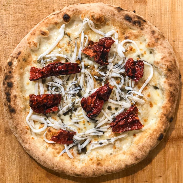 La pizza Virgilio Martinez: peperone corno arrostito, tagliatella di seppia cotta a bassa temperatura, fiordilatte e un’emulsione al nero, limone e olio extravergine d'oliva. Disponibile fino al 30 Giugno a La Cascina dei Sapori
