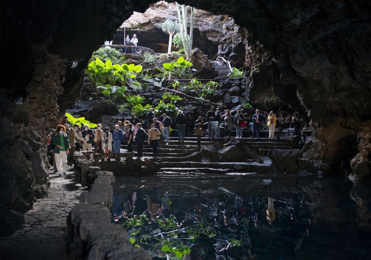 Worldcanic took place in beautiful places in Lanzarote. Here you see the Jameos del Agua, a natural place and artistic, cultural and touristic centre created by César Manrique (a polyhedric artist, painter, sculptor, architect, ecologist, preserver of the artistic heritage, urban and landscape designer from Lanzarote). He convinced the other locals to invest in tourism without making the mistakes made in other areas of the country and of the planet, thus not allowing to ruin the landscape with buildings that would not be in tune with the volcanic nature of the island). The Jameos del Agua are one of the most appreciated destinations. The word jameo has Aboriginal origins and refers to a hole made when the roof of a lava tunnel collapses. Jameos del Agua can be found inside the volcanic tunnel produced by the eruption of the volcano de la Corona. The known length of the tunnel is 6 km, of which at least 1.5 km under the sea: this latter section is called Tunnel of Atlantis. The Jameos del Agua are in the section of this tunnel that is close to the coast. They are made of at least three “jameos”, or openings in the soil
