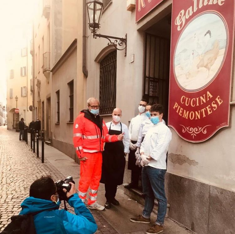 Andrea Chiuni, il responsabile di Croce Verde Marco Crema e alcuni ragazzi del ristorante Tre Galline fotografati da un reporter di France Press
