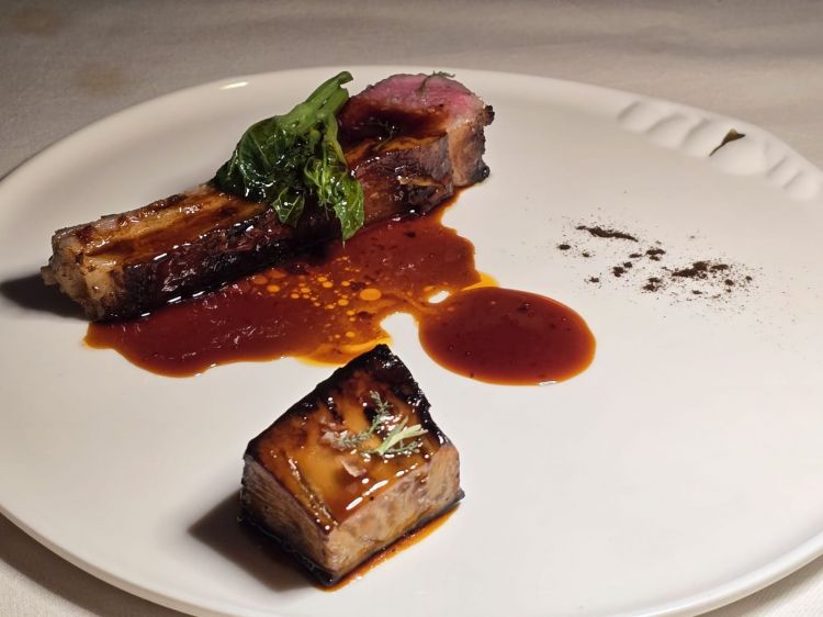 Agnello di Giuseppe Grasso in salsa d’origano. «L’agnello del mio amico allevatore Giuseppe Grasso si mangia fino all’osso. Viene ammorbidito e insaporito con una marinatura koji. Poi, doppia cottura prima in olio poi in Bull, riposo in caldo per quindici minuti a 60 gradi. Cucinato tutto il grasso e lasciata media la carne, otteniamo una cottura burrosa»