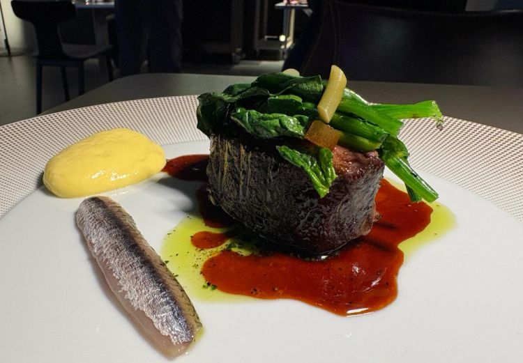 Agnello cacio e uova, alici marinate e capperi
&laquo;&Egrave; una ricetta che unisce due preparazioni tipiche della cucina pastorale: l'agnello brodettato e la salsa cacio e ova, dove le uova venivano rotte nel brodo con il pecorino per addensare e rendere il tutto cremoso. Noi lavoriamo gli scampoli del coscio, lasciati maturare in una fermentazione di ceci della Tuscia per rompere le proteine e ammorbidire la carne, poi finiamo tutto al barbecue. Alla base un battuto di prezzemolo e capperi con il fondo di agnello, talli d'aglio alla brace conservati in agrodolce, spinaci al barbecue. La salsa cacio e ova &egrave; una spuma fatta con brodo di agnello, pecorino Monte Niro stagionato ventiquattro mesi e uova, infine messa nel sifone per darle ariosit&agrave;&raquo;
