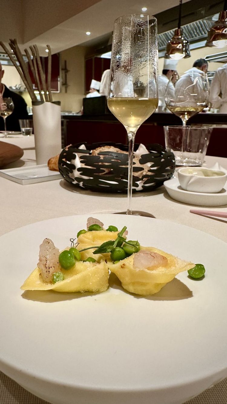 Ravioli farciti di latte cagliato di capra, insalata di piselli, gamberi rosa marinati, accompagnati con Acqua di baccelli di pisello e prosciutto: un ricordo degli anni 80, con le tre "p" (panna, prosciutto e piselli) trasformate, rispettivamente, in latte cagliato di capra e in un estratto impressionante per la sua concentrazione di sapore. È la dimostrazione di come un ricordo o un piatto che tutti conoscono possano rivivere oggi, trasformati in alta cucina
